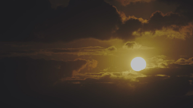 Sun setting behind dark clouds