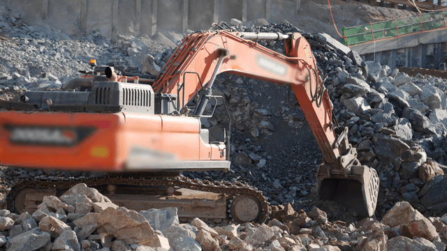 Excavator working on rocky terrain