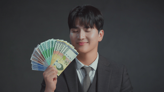 Man holding Korean banknotes with a smile