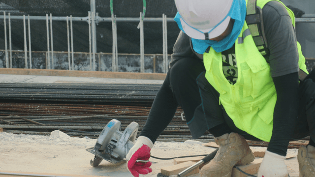 Construction worker measuring wood on site