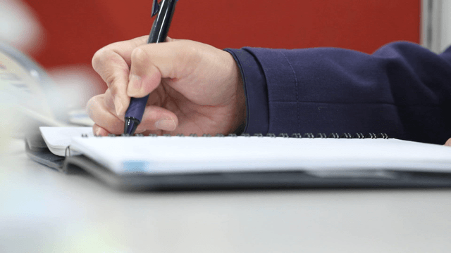 Person writing notes in a notebook