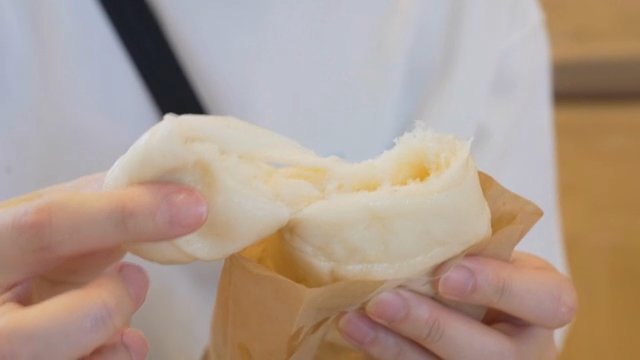 A person enjoying a steamed bun