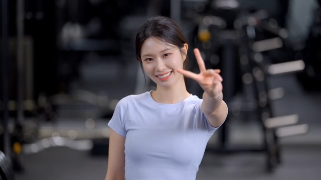 Smiling woman making a V sign in a gym