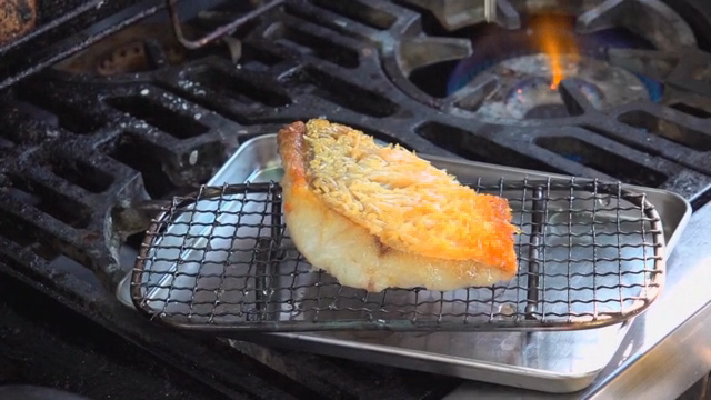 Taking fried fish out of the pan