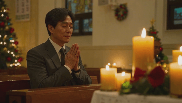 Man praying in a candlelit church