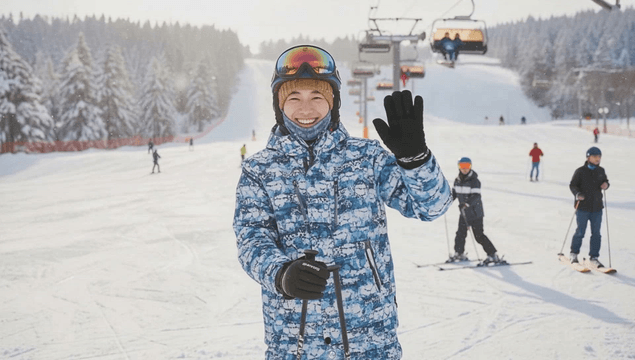 Man skiing on a snowy slope smiling at the camera