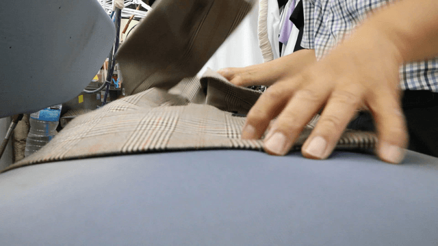 Person ironing clothes in a laundry shop