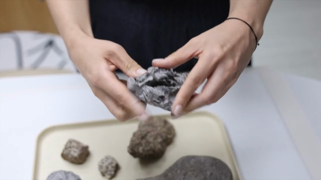 Hands molding clay indoors