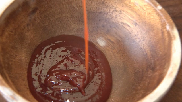 Pouring sauce into a wooden bowl