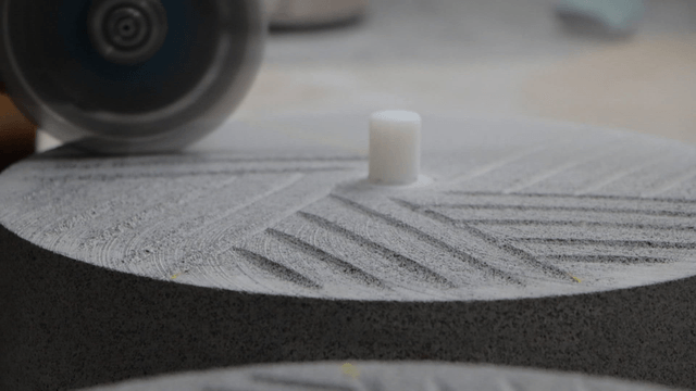 Grinder creating patterns on basalt millstone surface