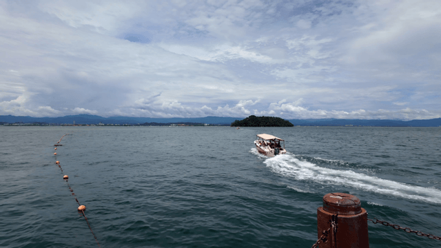 A boat sailing towards a distant island