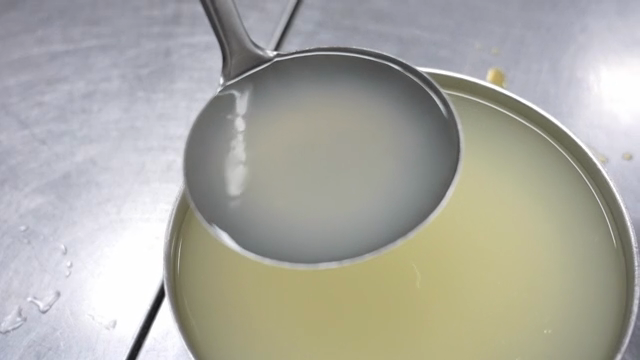 Ladle scooping liquid from a pot