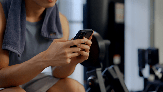 Man using smartphone at the gym