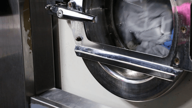 Clothes spinning inside a laundromat washing machine