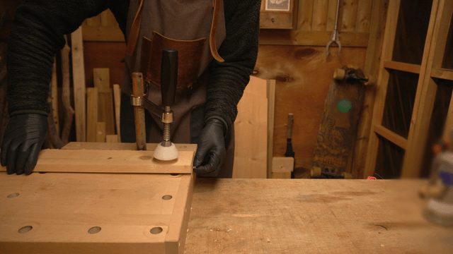 Woodcraft artisan securing wood on workbench with clamp