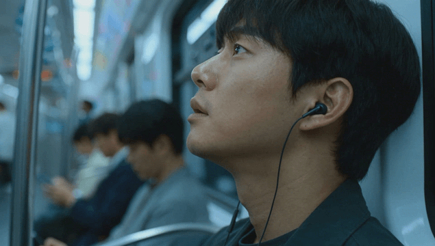 Man listening to music with wired earphones in the subway