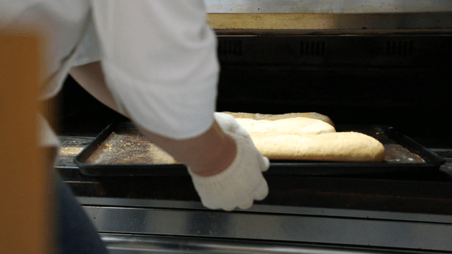 Baker taking bread out of the oven