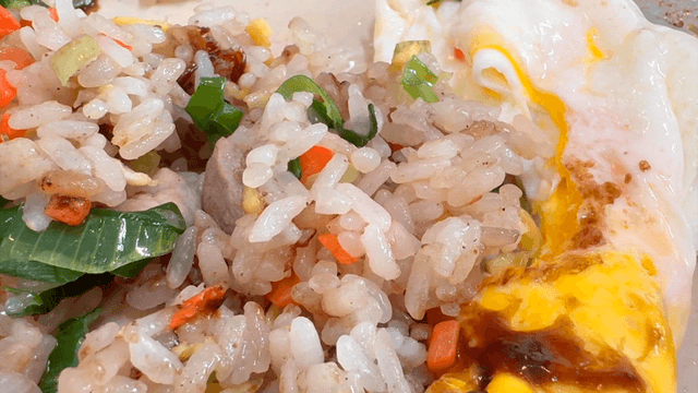 Chinese fried rice topped with fried egg and vegetables