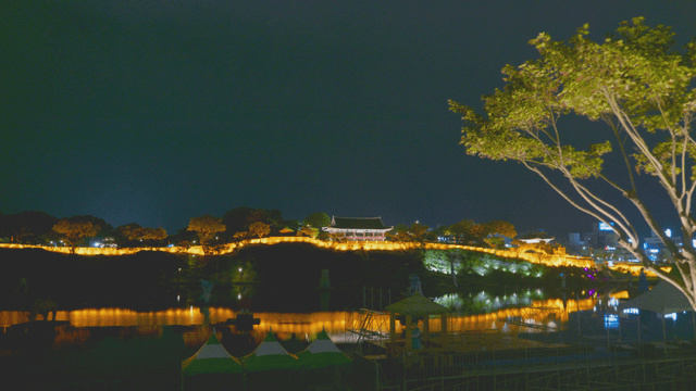 Lights illuminating a riverside traditional hanok pavilion