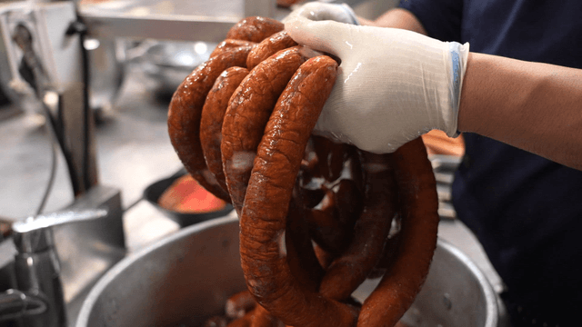 Chef taking sausages out of ice water in kitchen