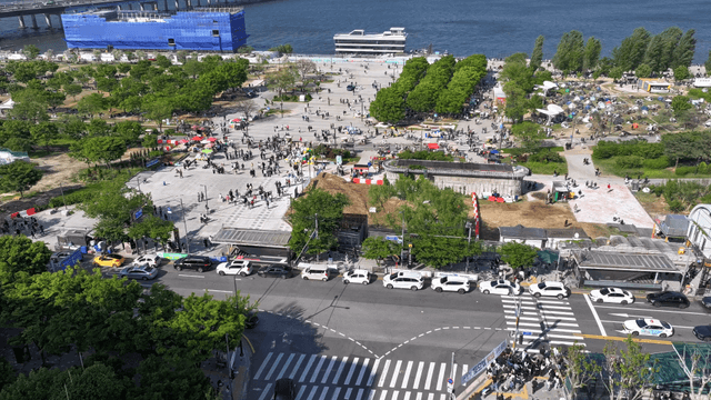 A bustling city square with people and cars