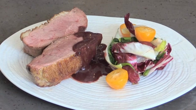 A plate of duck steak with salad