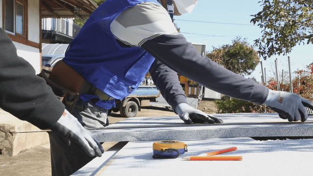 Workers measuring and cutting materials