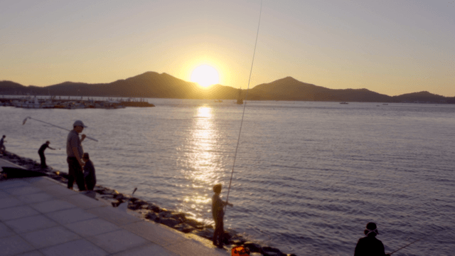 해질녘 바다에서 낚시하는 사람들