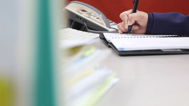 Person writing notes at a desk