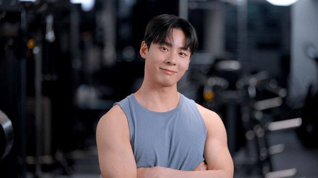 Young man smiling with arms crossed in gym