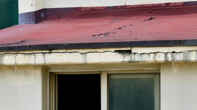 Damaged building facade with cracks
