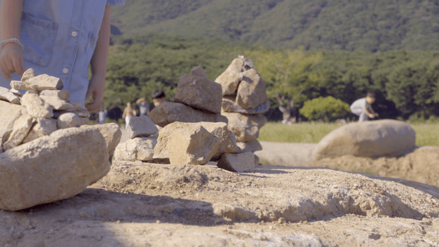 들판에서 돌을 쌓는 아이