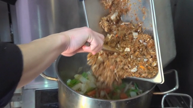 Chef adding ingredients to a pot
