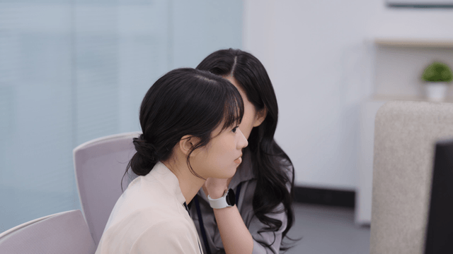 사무실에서 일하며 대화하는 두 여성