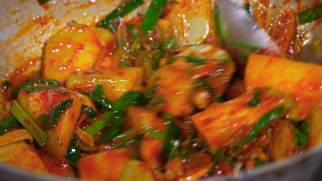 야채를 양념과 함께 요리하는 장면