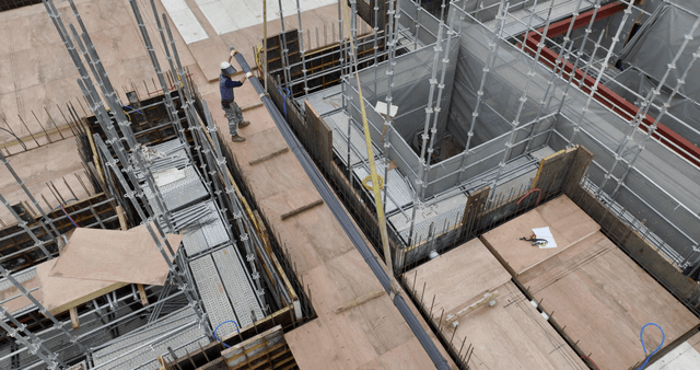 Construction workers guiding a crane load