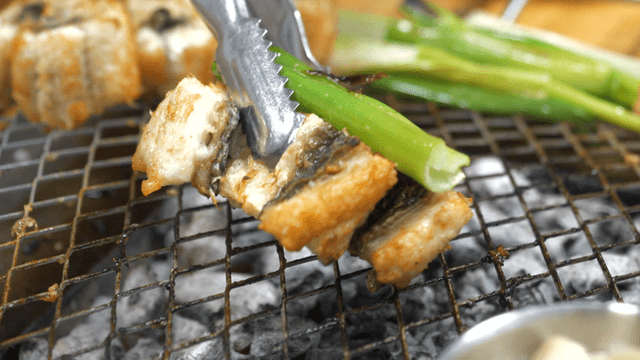 Grilled eels served with roasted green onions