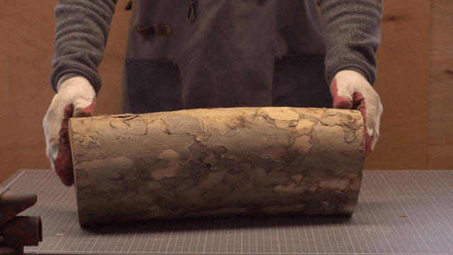 Carpenter handling wooden logs in workshop