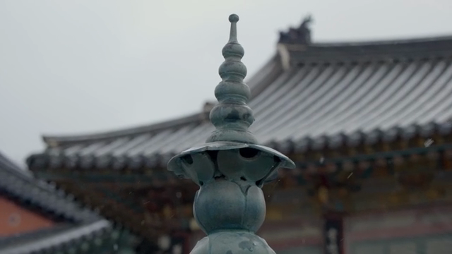 Traditional Korean temple with snow falling