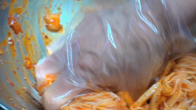 Spicy noodles being mixed in a bowl