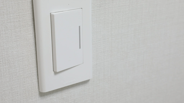 White light switch on a textured wall