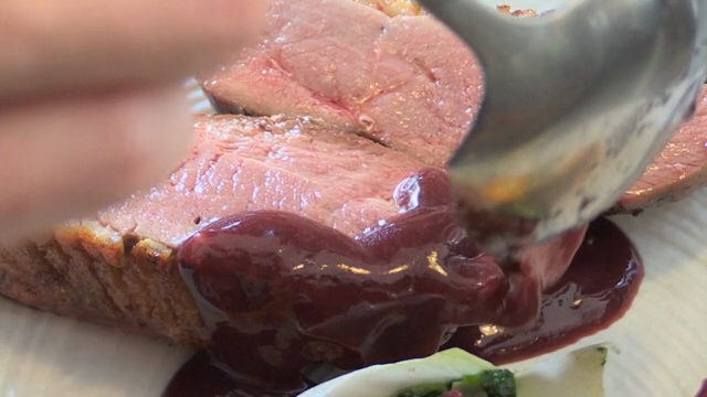 A scene of pouring sauce on plated duck meat