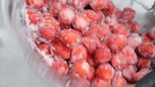 Mixing strawberries with sugar in a bowl