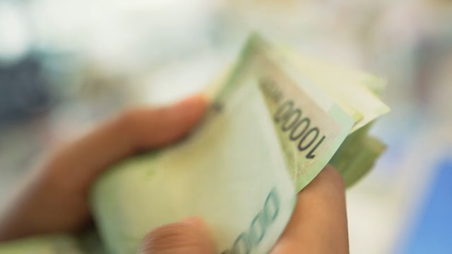 Counting Korean banknotes in hand