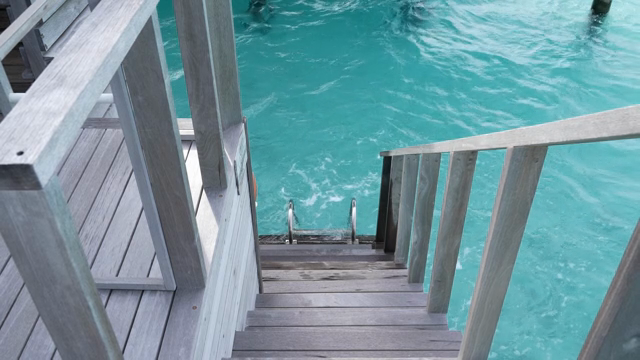 Wooden stairs leading to clear blue water