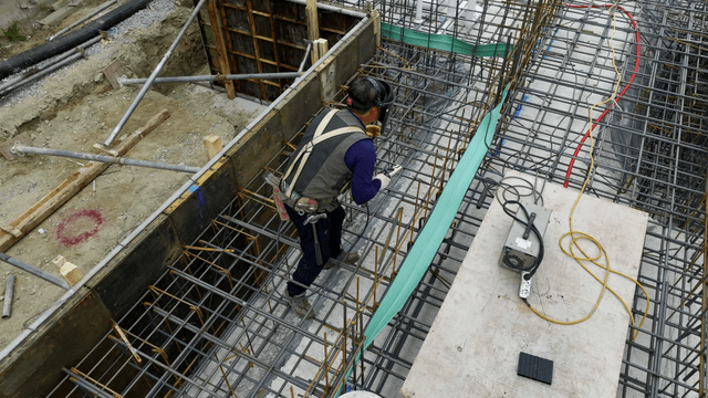 Construction worker welding rebar
