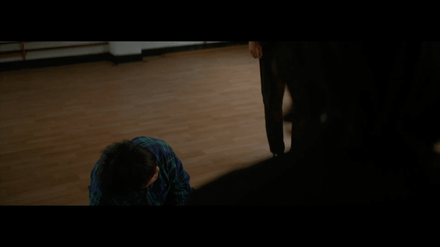 Person kneeling on a wooden floor