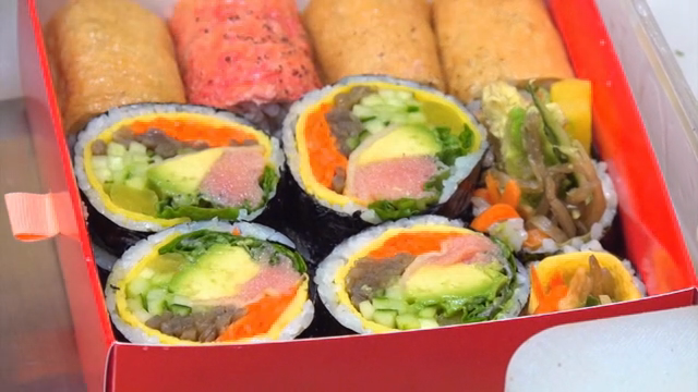 Kimbap being prepared in a lunchbox