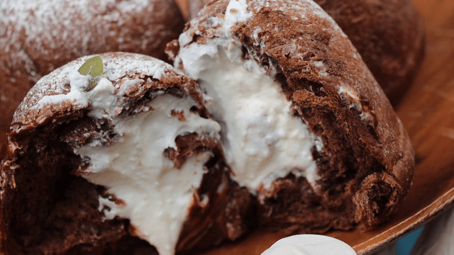 Cream-filled pastries on a wooden plate