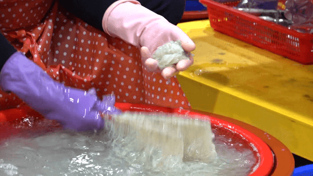 Process of trimming ice fish with chopsticks in market